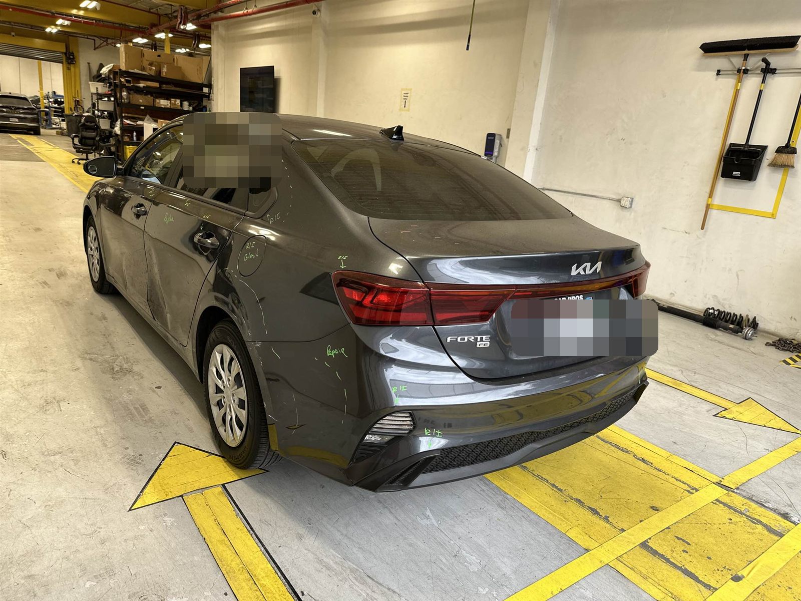 Gray Kia Forte with driver-side and rear collision damage, as it arrived